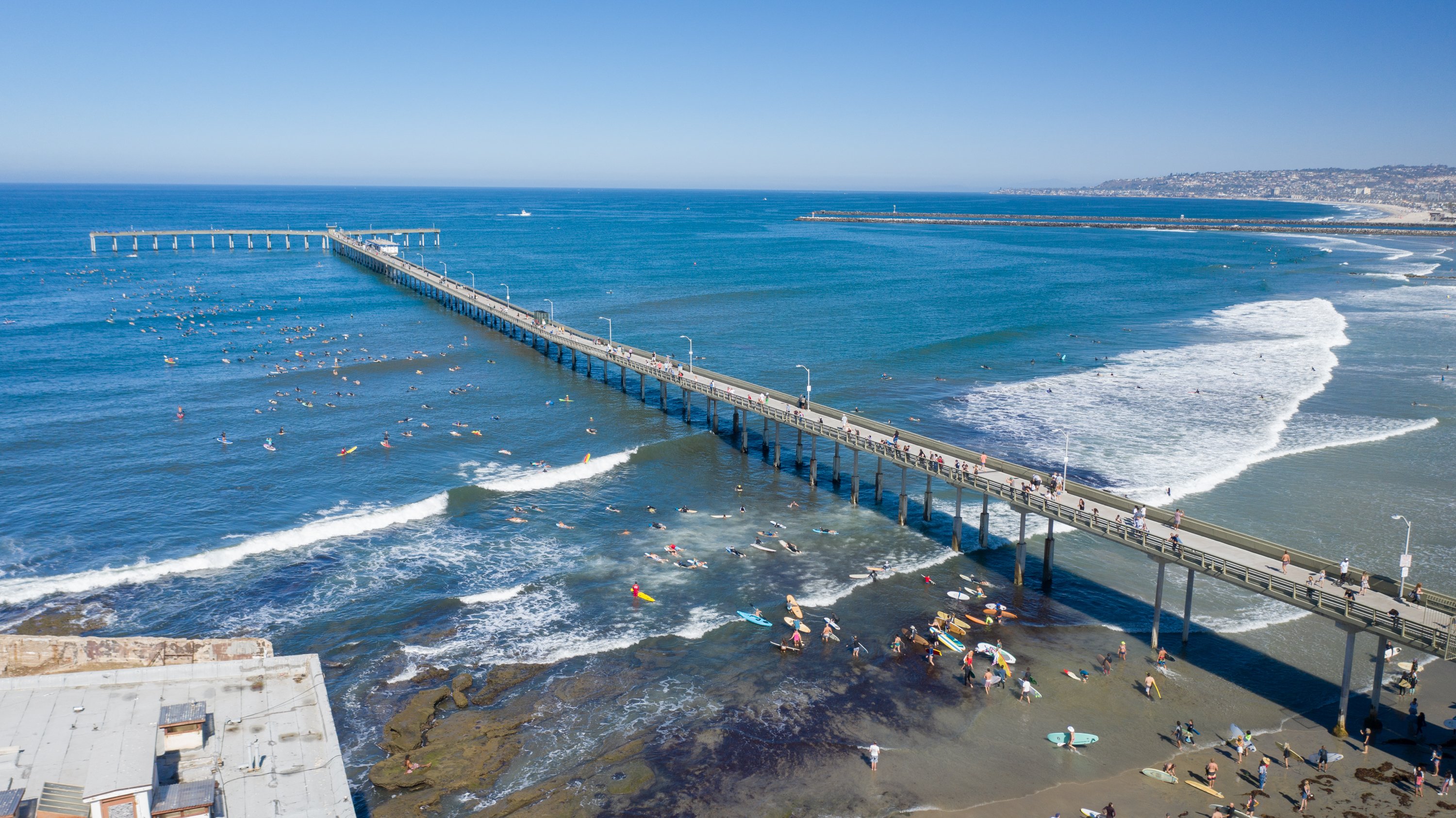 A drone shot of the entire pier from the south side, looking west from the shore. 